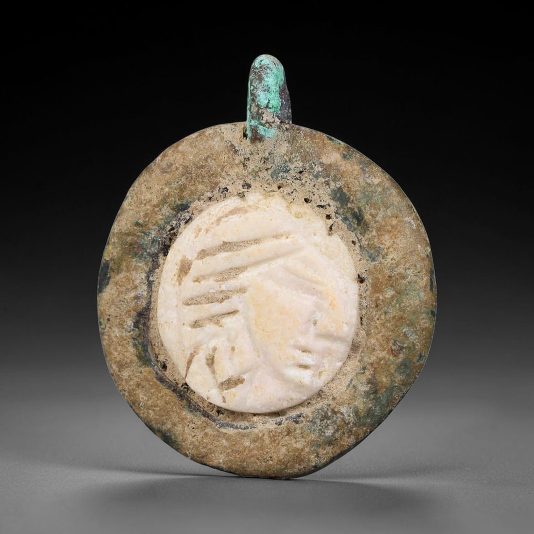 Ancient Medieval Byzantine Bronze Pendant With Stone Cameo (500-1200 CE), 13EG: This antique circular bronze pendant originates from medieval Byzantine cultural tradition, set with an inset carved stone cameo and made to serve as a wearable protective personal amulet. The bronze 
