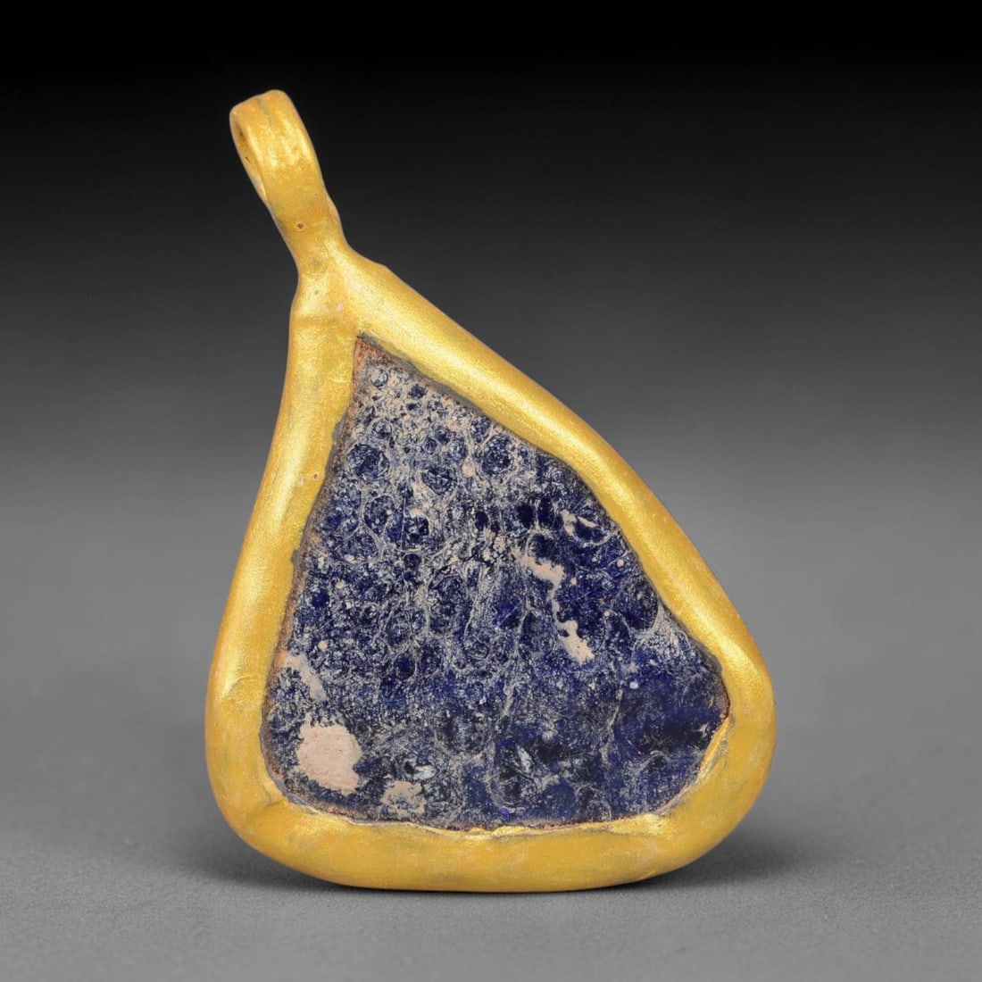 Ancient Roman Glass Slag in Modern Gilt-Edge Pendant, 35EH: This contemporary pendant is crafted from ancient Roman glass slag, featuring a fragmented, iridescent glass surface with weathered patina. The irregular form is bordered by a subtle gilt frame, added