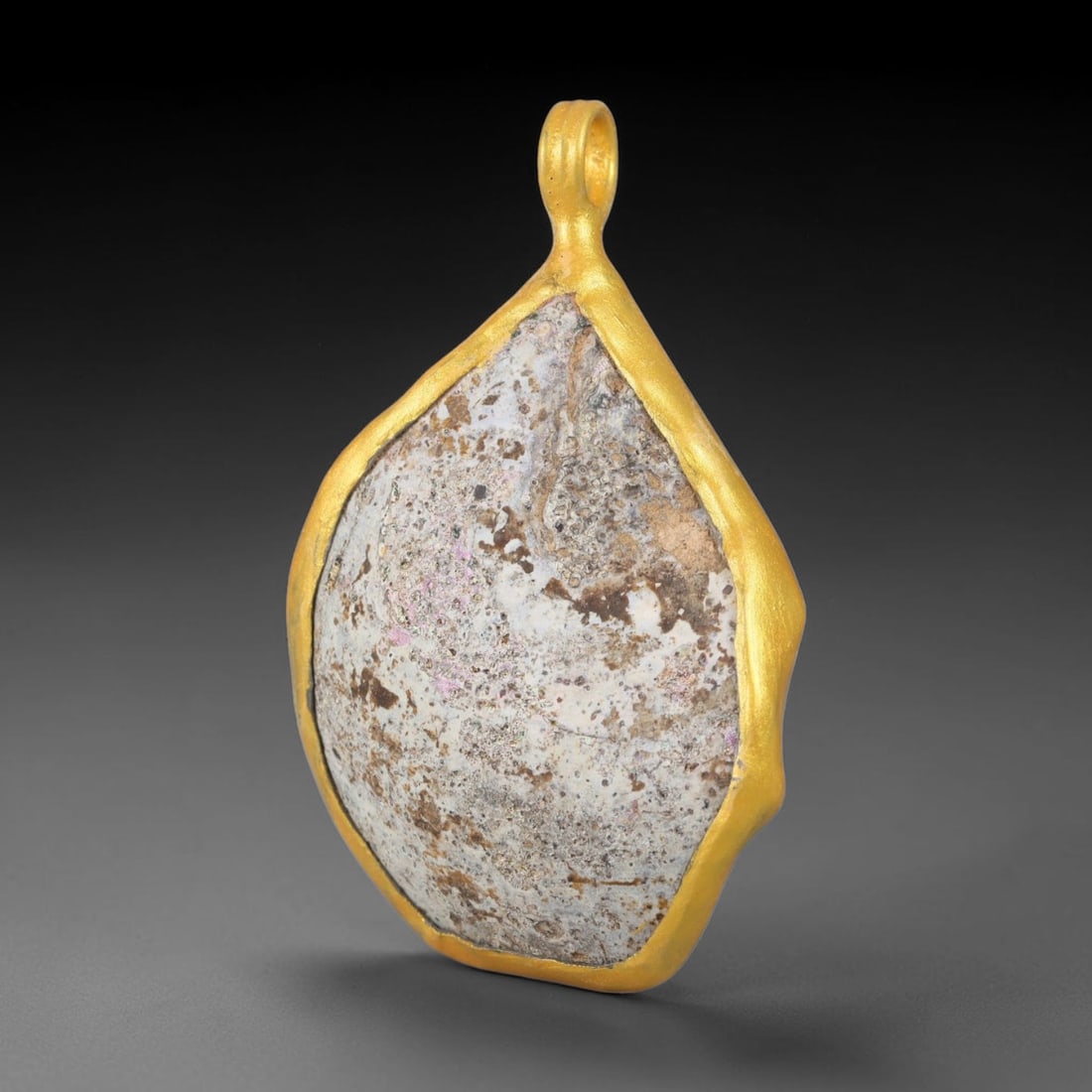 Ancient Roman Glass Slag in Modern Gilt-Edge Pendant, 23EH: This contemporary pendant is crafted from ancient Roman glass slag, featuring a fragmented, iridescent glass surface with weathered patina. The irregular form is bordered by a subtle gilt frame, added