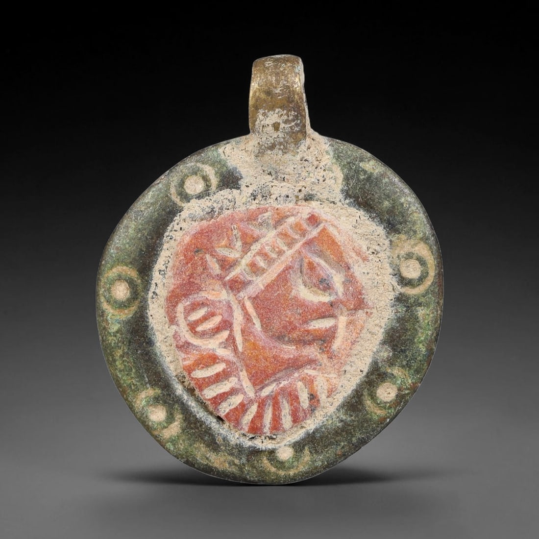 Ancient Medieval Byzantine Bronze Pendant With Stone Cameo (500-1200 CE), 41EH: This antique circular bronze pendant originates from medieval Byzantine cultural tradition, set with an inset carved stone cameo and made to serve as a wearable protective personal amulet. The bronze 