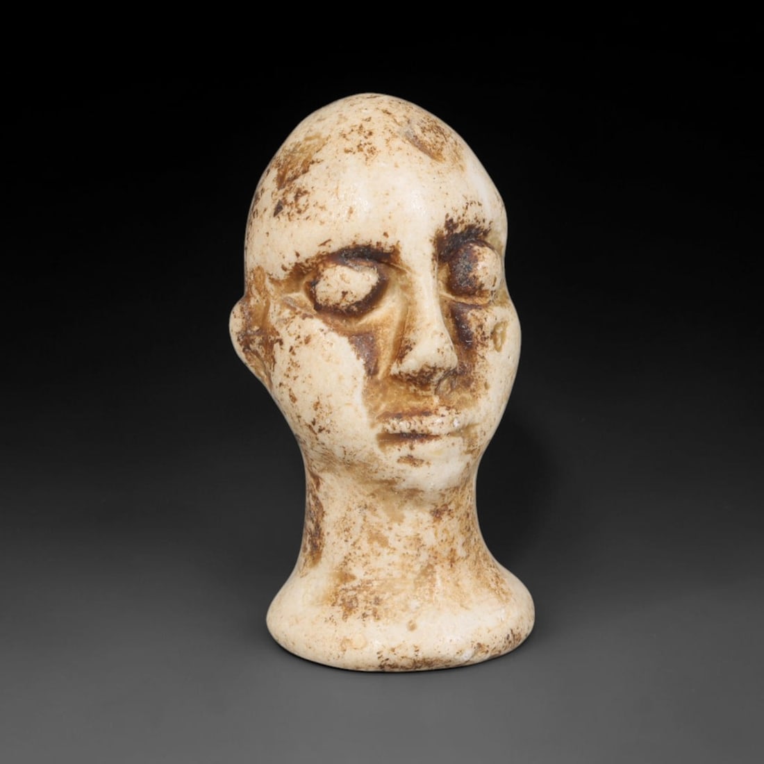 Ancient Bactrian Marble Idol Head (250 BCE-200 CE), 6EF: This carved pale marble idol head originates from Greco-Bactrian Culture, a significant Silk Road civilization blending Hellenistic and Central Asian artistic traditions. The simplified facial feature