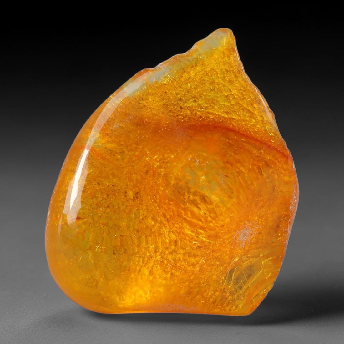 16.57ct Natural Baltic Polished Loose Freeform Amber Gemstone, 35AT: This smoothly polished freeform amber piece carries warm translucent organic clarity with fine natural fossil flecks and tiny mineral inclusions suspended throughout its 28x22mm flowing unstructured s