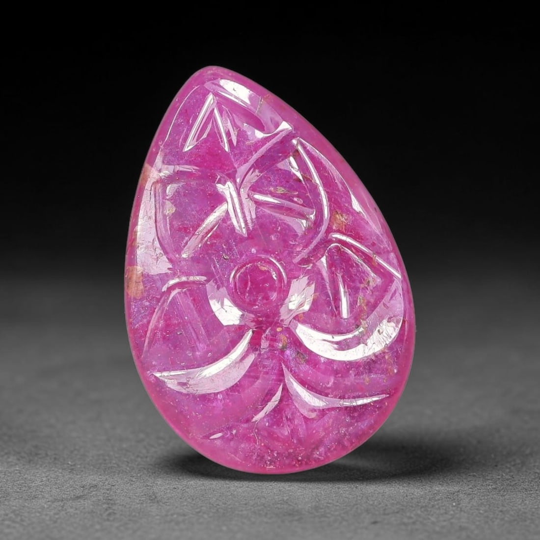7.90 Carats Natural Mozambique Rich Fuchsia Ruby Loose Gemstone, 38FE: This natural Mozambique ruby cabochon measures 17.4x12x3.1mm and features delicate hand engraved floral detailing carved across its polished surface, with a rich saturated fuchsia hue spread evenly th