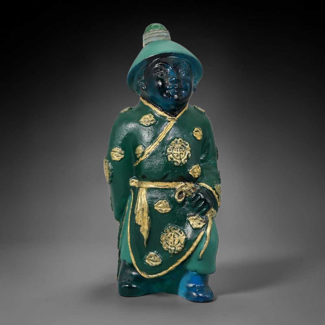 Vintage Chinese Liuli Glass Snuff Bottle - Standing Robed Attendant, 43AS: This snuff bottle is moulded from translucent teal liuli glass and shaped as a standing attendant with a traditional brimmed hat topped with a green bead stopper. The deep green robe is decorated with