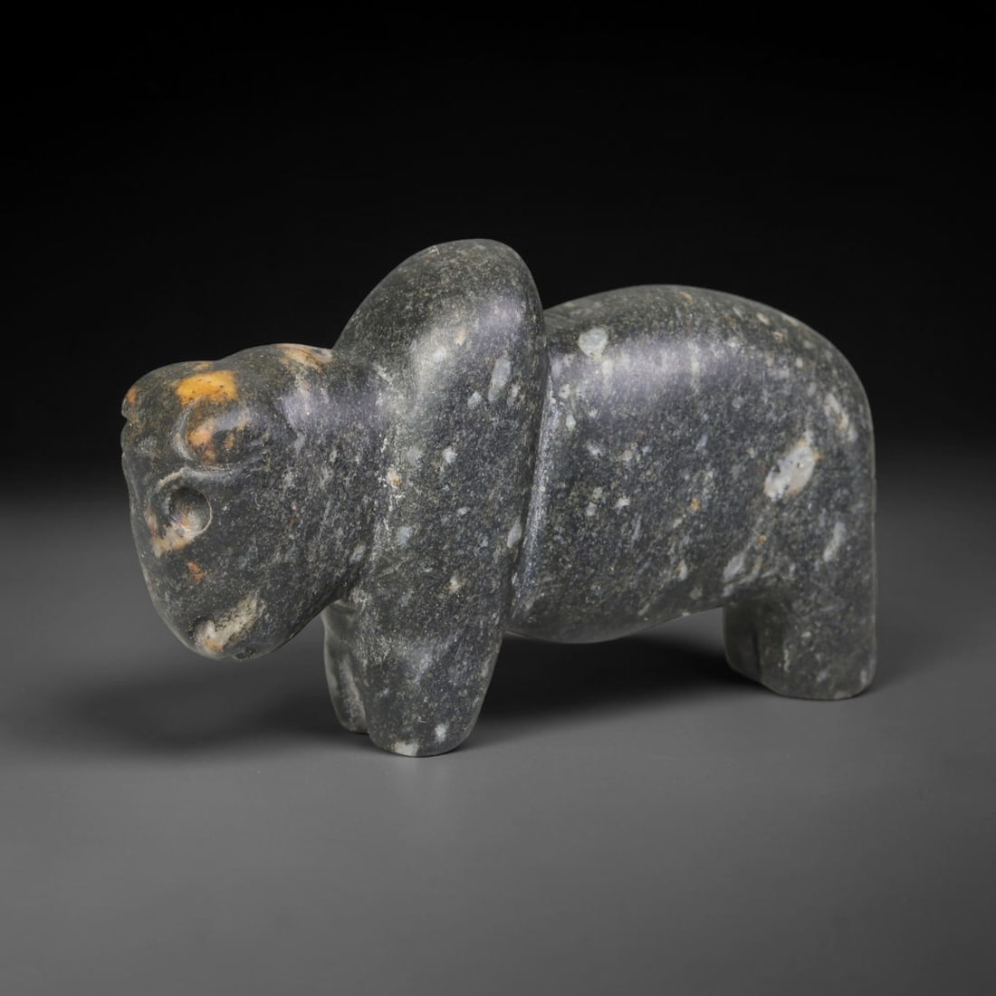 Ancient Near Eastern Speckled Dark Stone Zoomorphic Amulet, 96ED: This antique zoomorphic carving is crafted from speckled dark stone, originating from the Ancient Near East. Rendered in a standing zoomorphic form with simplified, rounded contours and natural minera