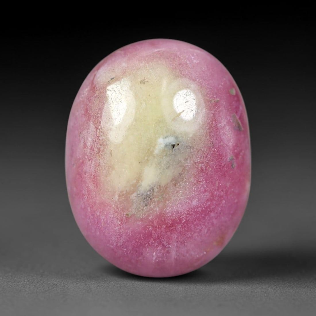 21.08 Carats Natural Mozambique Bicolor Ruby Loose Gemstone, 54FG: This natural Mozambique bicolor ruby cabochon holds dimension measurements of 17.3x13.5x7.8mm, displaying soft swirled intermix of rich pink and pale creamy mineral tones that blend seamlessly across 