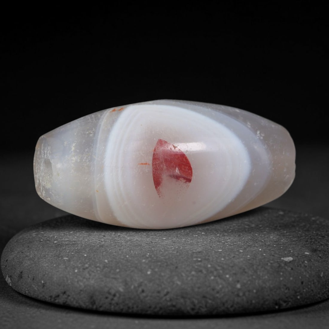 Ancient Kushan Empire Eye Banded Agate Barrel Bead (30 BCE - 375 CE), 82AD: This antique eye banded agate barrel bead originates from the Kushan Empire, a vital Silk Road cross-cultural realm famed for producing talismanic agate beads valued for protective symbolism, traded a