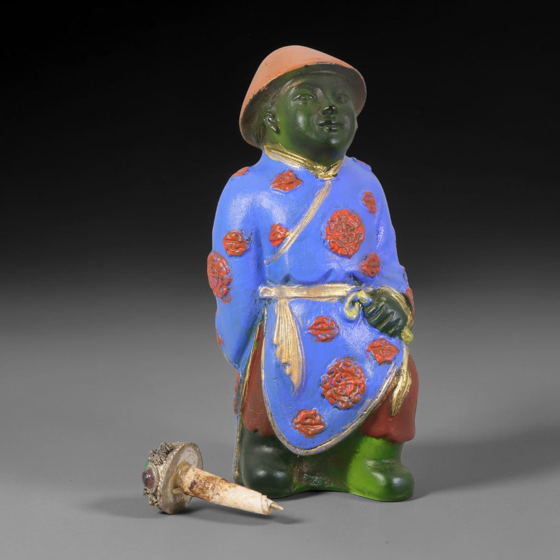 Vintage Chinese Liuli Glass Snuff Bottle - Standing Robed Attendant, 45AS: This snuff bottle is moulded from translucent green liuli glass, formed as a standing attendant figure wearing a rounded cap. The bright blue robe is decorated with hand-painted red floral medallions 