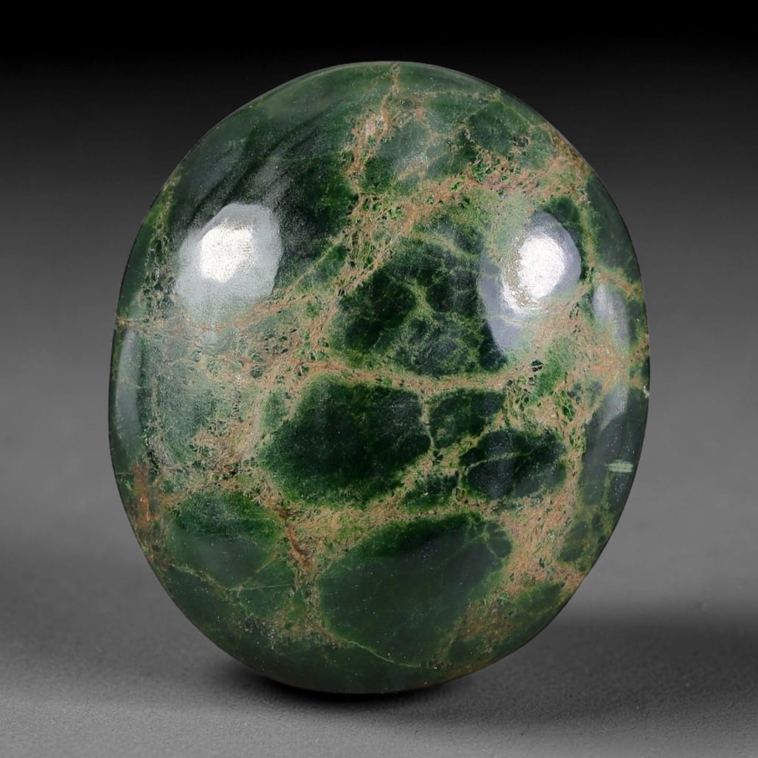 22ct Natural Burmese Type A Dark Green Web Vein Jadeite Jade Cabochon, 21FA: This single untreated natural Burmese Type A oval jadeite jade cabochon weighs 22ct with dimensions of 24.3x20.6x5mm. The deep forest green base is naturally interlaced with brownish mesh fracture vei