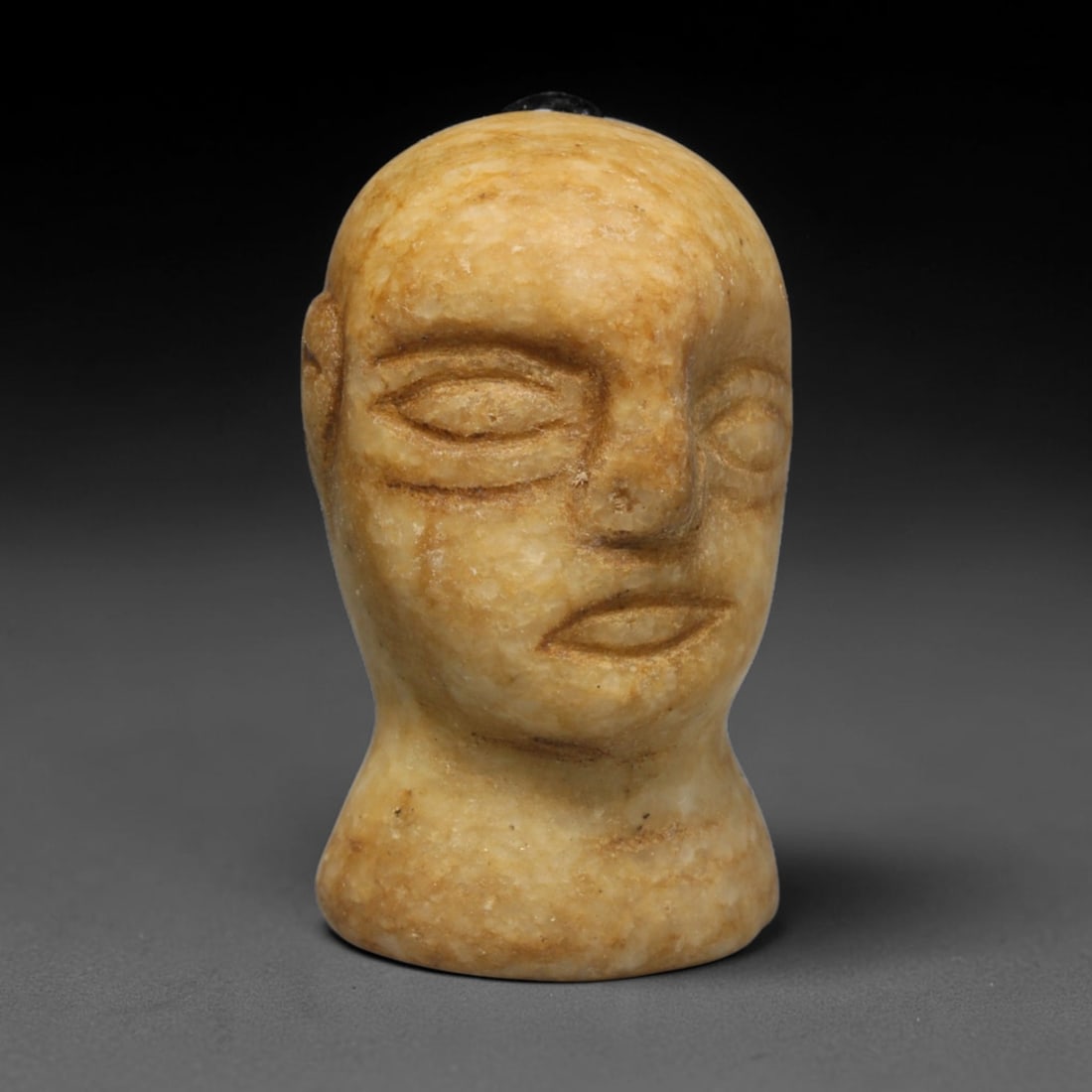 Ancient Bactrian Marble Idol Head (250 BCE-200 CE), 32ED: This carved pale marble idol head originates from Greco-Bactrian Culture, a significant Silk Road civilization blending Hellenistic and Central Asian artistic traditions. The simplified facial feature