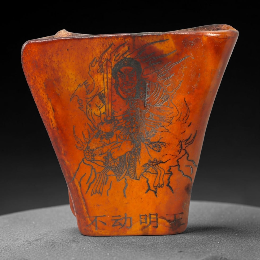 A Chinese Carved Bone Figural Plaque, 20th Century, 65FC: Carved from a thick section of bone with a warm amber-brown patina and natural translucency, the object is formed as a vertically oriented plaque with a flaring trapezoidal profile. The surface is eng
