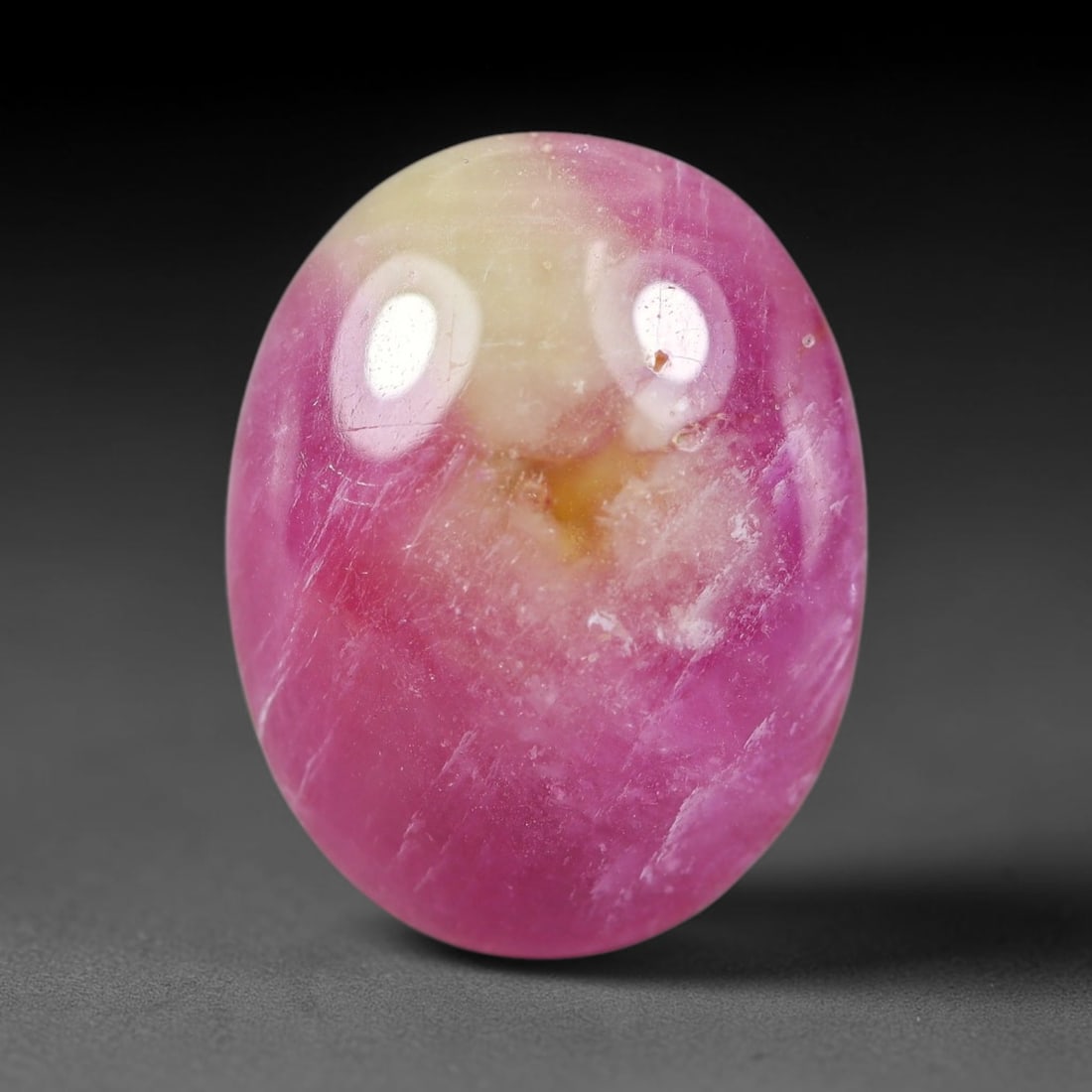 17.35 Carats Natural Mozambique Bicolor Ruby Loose Gemstone, 53FG: This natural Mozambique bicolor ruby cabochon holds dimension measurements of 18.8x14.7x6.1mm, displaying soft swirled intermix of rich pink and pale creamy mineral tones that blend seamlessly across 