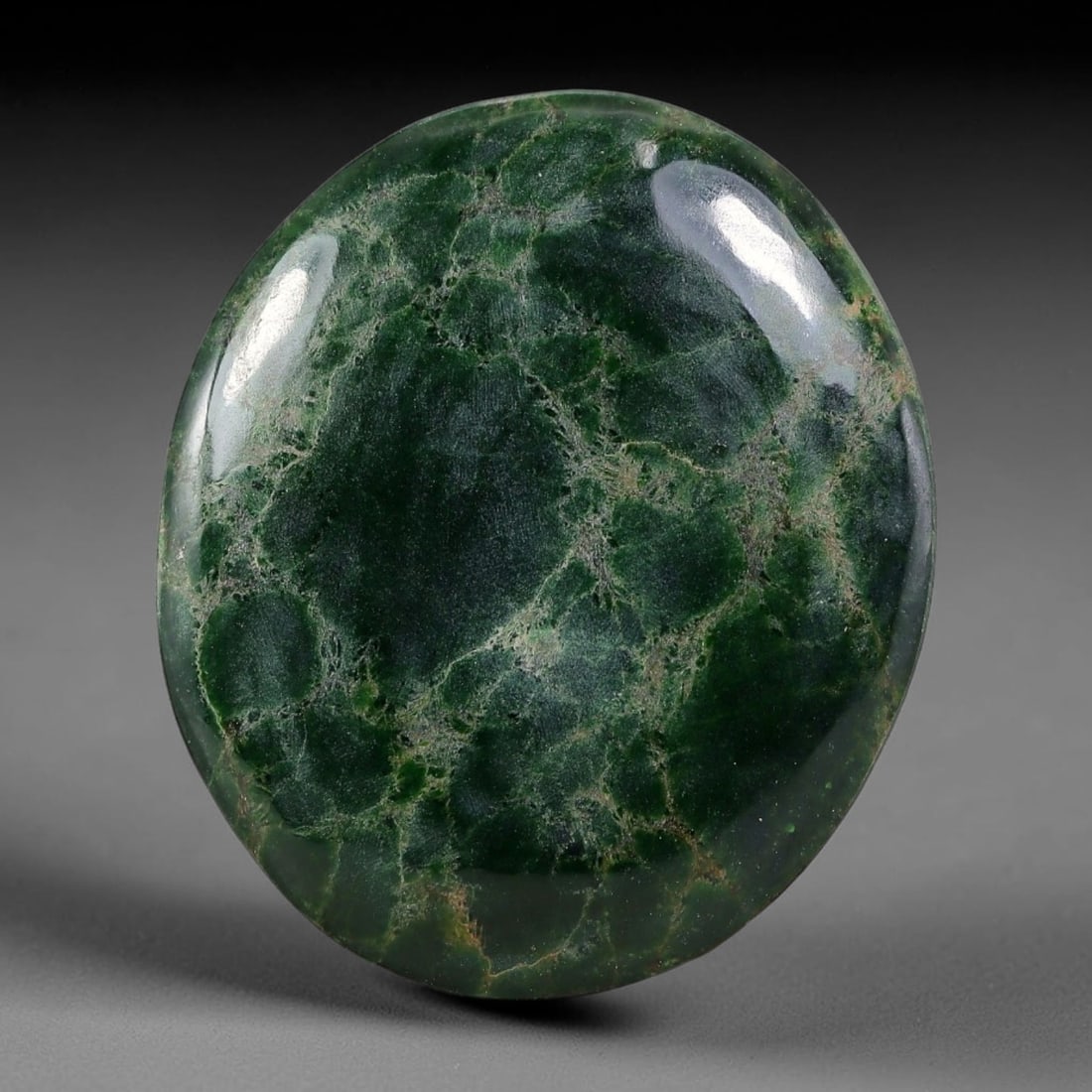 27.57ct Natural Burmese Type A Dark Green Crackle Vein Jadeite Jade Cabochon, 36FA: This single untreated natural Burmese Type A oval jadeite jade cabochon weighs 27.57ct with dimensions of 28.2x23.8x4mm. The deep forest green body is interlaced with fine brownish crackle veins that 