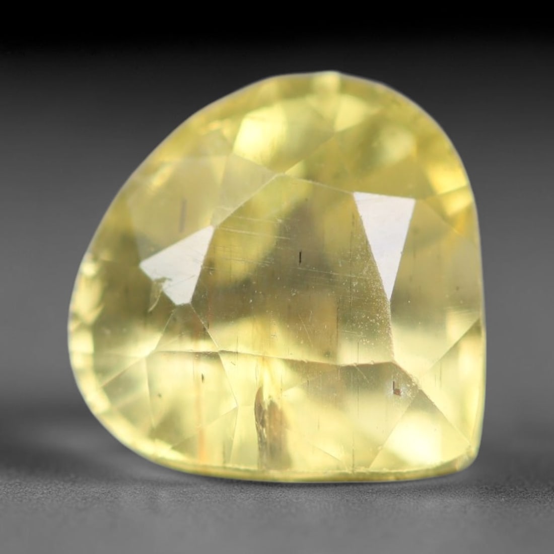2.14ct Natural Mexican Lemon Yellow Faceted Apatite Loose Gemstone, 27BC: This expertly faceted yellow apatite holds translucent pale lemon yellow crystal structure with faint tiny internal mineral specks and subtle fine linear markings visible beneath its precisely polishe