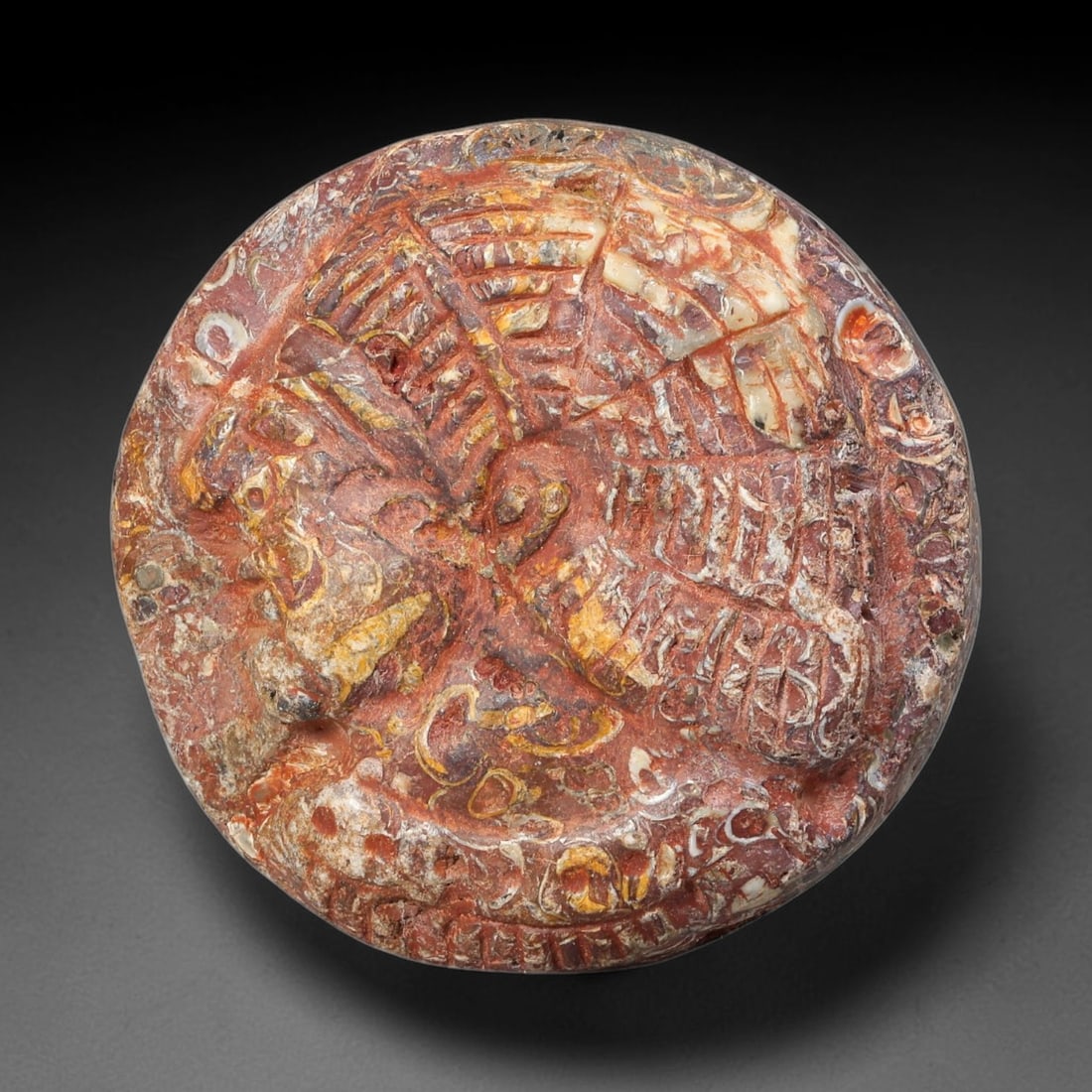 Ancient Syro-Hittite Fossil Stone Cameo Amulet Bead (1200-800 BCE), 29EF: This circular bead is crafted from naturally patterned fossil stone, originating from Iron Age Syro-Hittite cultures of Northern Syria and Eastern Anatolia. The surface bears a relief cameo carving of