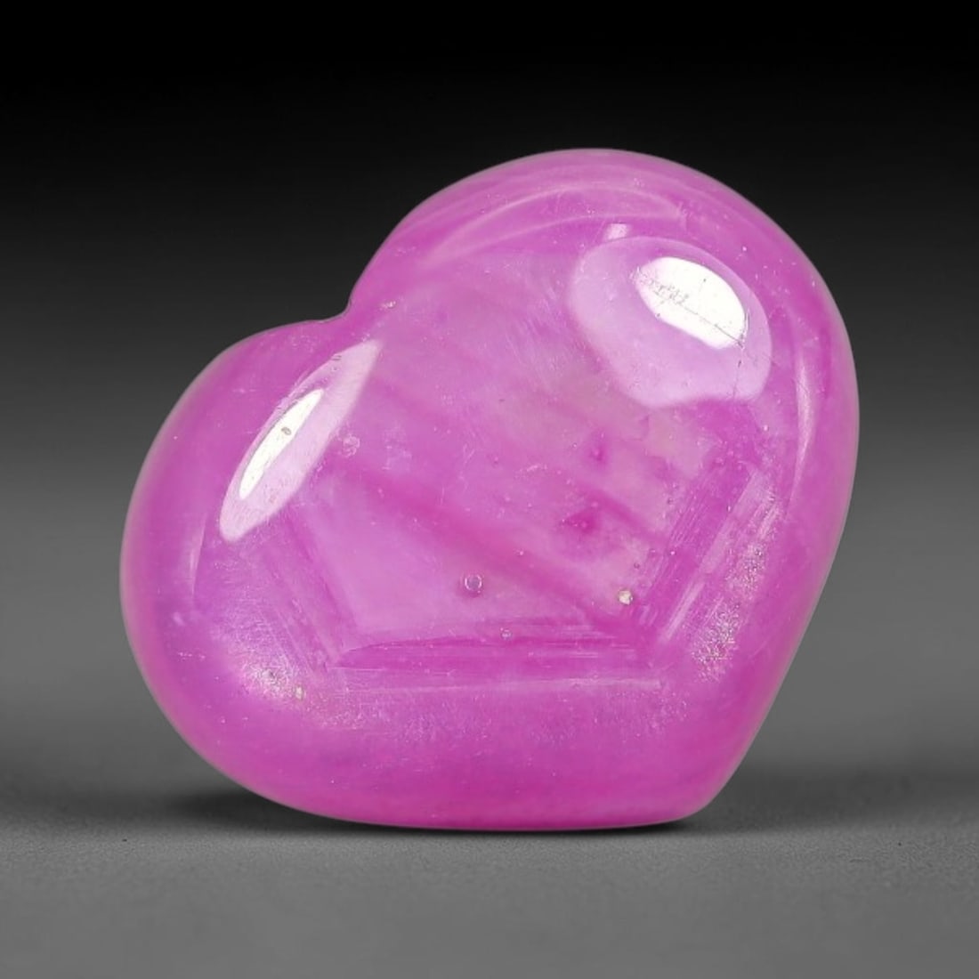 6.89 Carats Natural Mozambique Hot Pink Ruby Loose Gemstone, 55FE: This heart shaped Mozambique ruby cabochon measures 13x11x4.3mm, showcasing a vivid saturated hot pink body paired with stunning natural hexagonal crystal growth banding that forms a distinct geometri