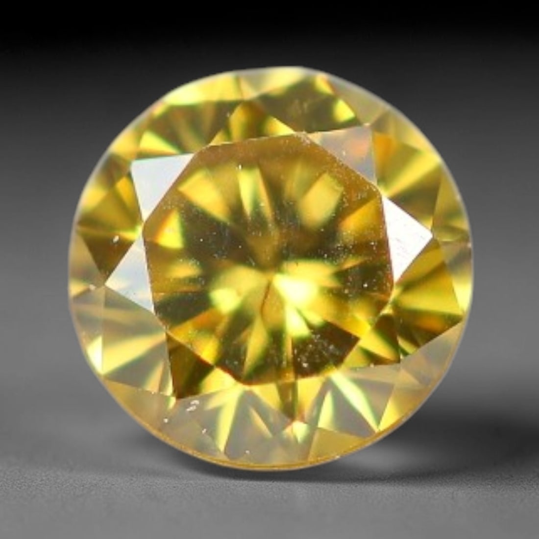 0.07ct Round Natural Fancy Vivid Yellow Diamond Loose Gemstone, 7BH: This polished natural round fancy diamond exhibits vibrant saturated yellow colour, with fine microscopic native mineral specks visible inside the crystal, measured at calibrated dimensions of 2.7x1.6
