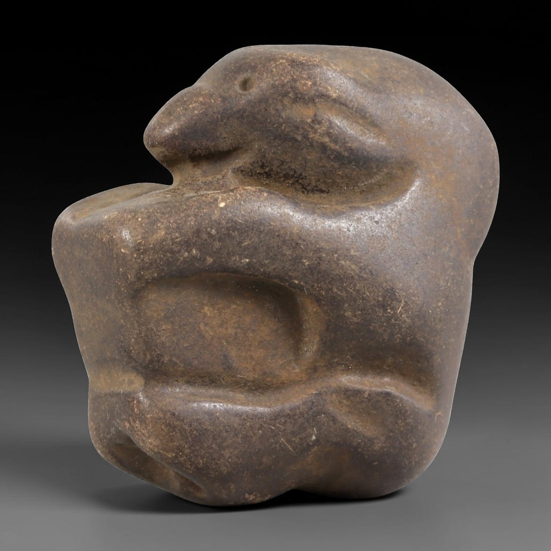 Ancient Stone Zoomorphic Effigy - Near Eastern Figurine, 5FY: Carved from a dense, smooth stone, this effigy depicts a stylized crouching animal-likely a rodent or small mammal-in a compact, rounded form. Relief details define the snout, circular eye socket, and