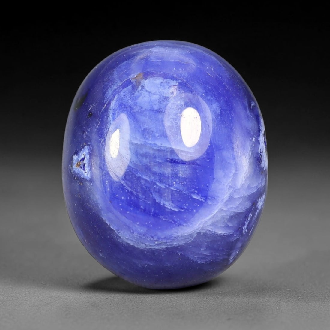 25.67 Carats Natural Madagascar Deep Cobalt Blue Sapphire Loose Gemstone, 24FE: This Madagascar sapphire cabochon has dimensions measuring 18.2x15x8.2mm, featuring rich cobalt blue color blended with soft natural pale veining that creates unique layered visual texture across the 