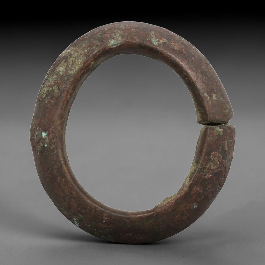 Ancient Bronze Bracelet - Roman Penannular Bangle, 27BN: A penannular bronze bracelet of ancient Roman origin, formed from a thick, robust bronze band with a rounded cross-section. The open terminals are plain and squared, characteristic of simple Roman pro