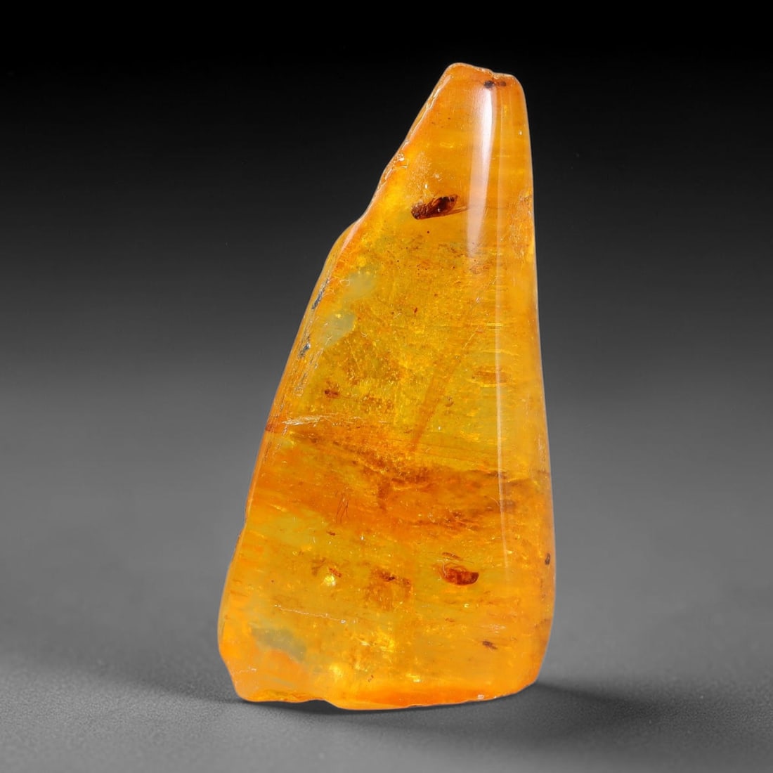 15.31ct Natural Baltic Polished Loose Freeform Amber Rough, 27EK: This smoothly polished freeform amber piece carries warm translucent organic clarity with fine natural fossil flecks and tiny mineral inclusions suspended throughout its 33x17x10mm flowing unstructure