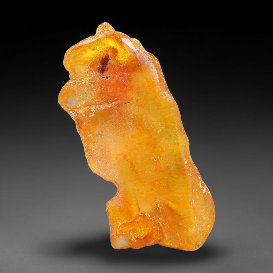 16.30ct Natural Baltic Polished Loose Freeform Amber Rough, 15EK: This smoothly polished freeform amber piece carries warm translucent organic clarity with fine natural fossil flecks and tiny mineral inclusions suspended throughout its 40x17x11mm flowing unstructure