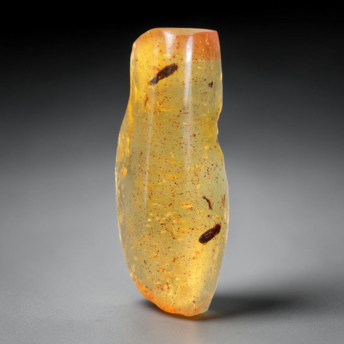 15.11ct Natural Baltic Polished Loose Freeform Amber Rough, 30EK: This smoothly polished freeform amber piece carries warm translucent organic clarity with fine natural fossil flecks and tiny mineral inclusions suspended throughout its 36x14x9mm flowing unstructured