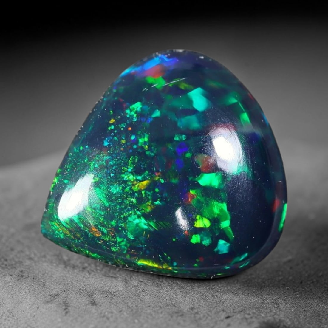 1.41ct Natural Ethiopian Welo Black Smoked Opal Cabochon Loose Gemstone, 68FX: This fully polished Ethiopian Welo opal features a dark smoked base with vivid, sweeping play-of-color shifting across its glossy dome surface, measured at 10x9x3mm. The black smoke treatment deepens 