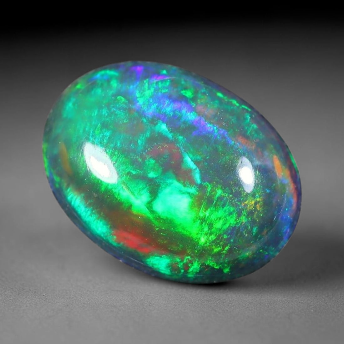 1.62ct Natural Ethiopian Welo Black Smoked Opal Cabochon Loose Gemstone, 43FX: This fully polished Ethiopian Welo opal features a dark smoked base with vivid, sweeping play-of-color shifting across its glossy dome surface, measured at 10x8x3mm. The black smoke treatment deepens 