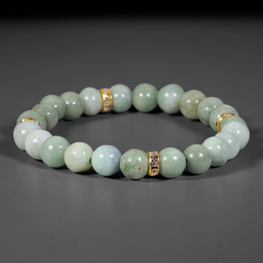 Natural Burmese Type A Jadeite Jade Beaded Bracelet, 16FJ: Polished natural jadeite jade round beads complemented by decorative gold tone crystal spacer accents. Uniform 8mm beads form a flexible wearable strand. A timeless gemstone bracelet suitable for dail