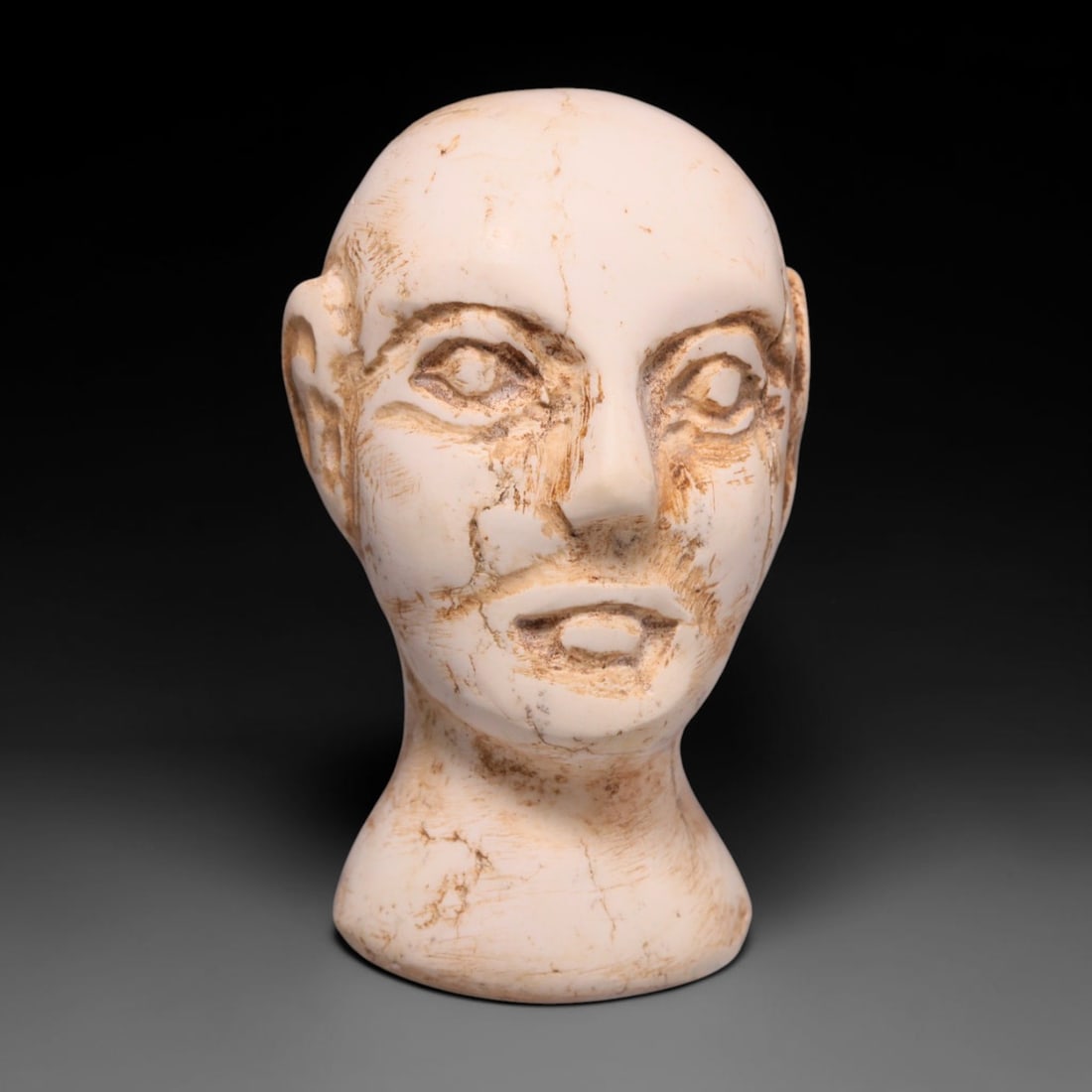 Ancient Bactrian Calcite Idol Head (c.2000-1500 BCE), 71EC: This miniature carved pale calcite idol head originates from Ancient Bactria, an early Central Asian civilisation famed for small anthropomorphic devotional figurines. The simplified facial features, 