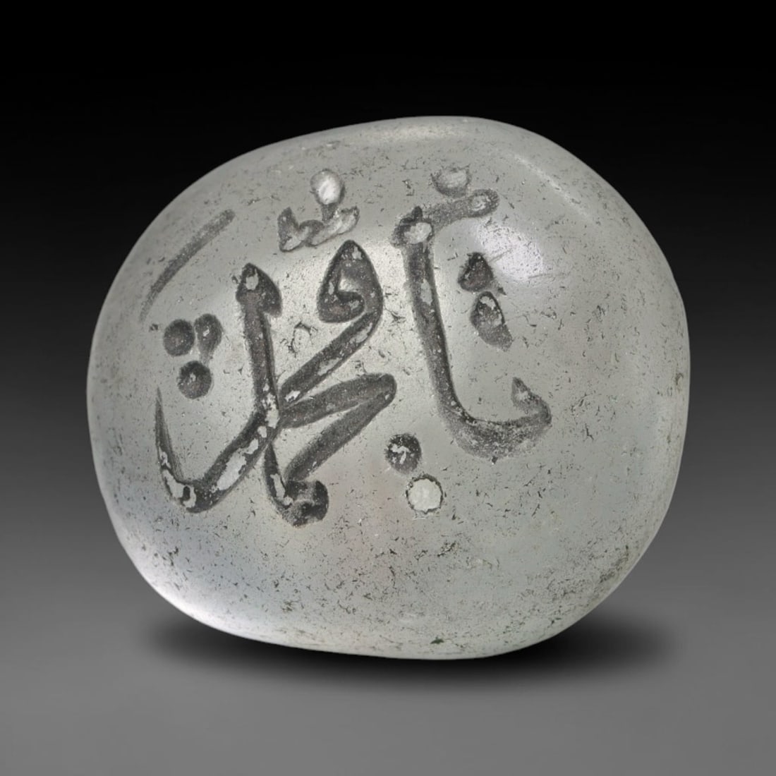 Early Vintage Islamic White Glass Calligraphic Intaglio Seal Cabochon (Post 1900 CE), 93BX: This early vintage glass intaglio seal cabochon draws from enduring Islamic seal-making traditions, formed from translucent pale glass with a smoothly rounded polished surface. The face features caref