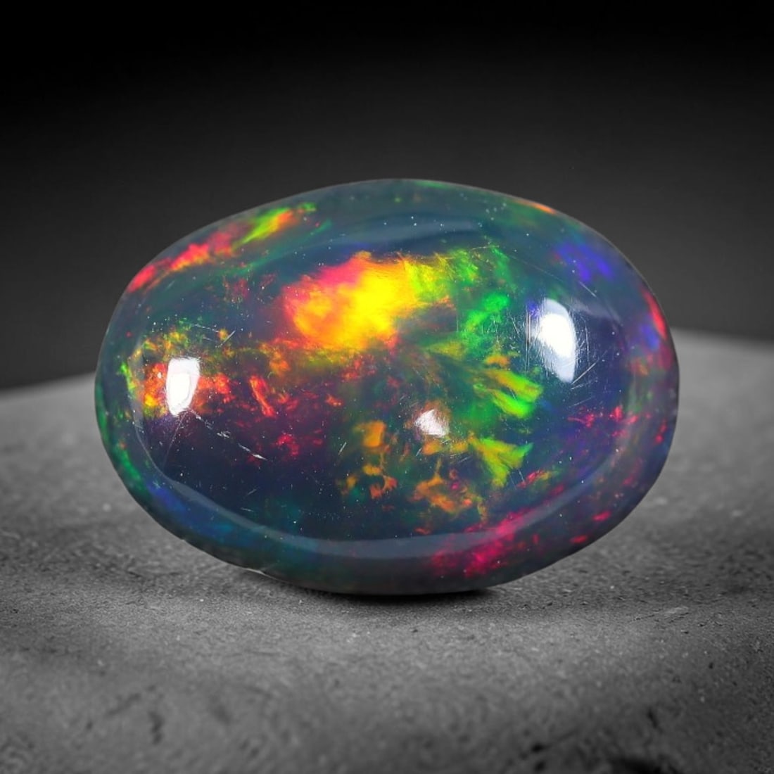 2.35ct Natural Ethiopian Welo Black Smoked Opal Cabochon Loose Gemstone, 22FX: This fully polished Ethiopian Welo opal features a dark smoked base with vivid, sweeping play-of-color shifting across its glossy dome surface, measured at 11x8x5mm. The black smoke treatment deepens 