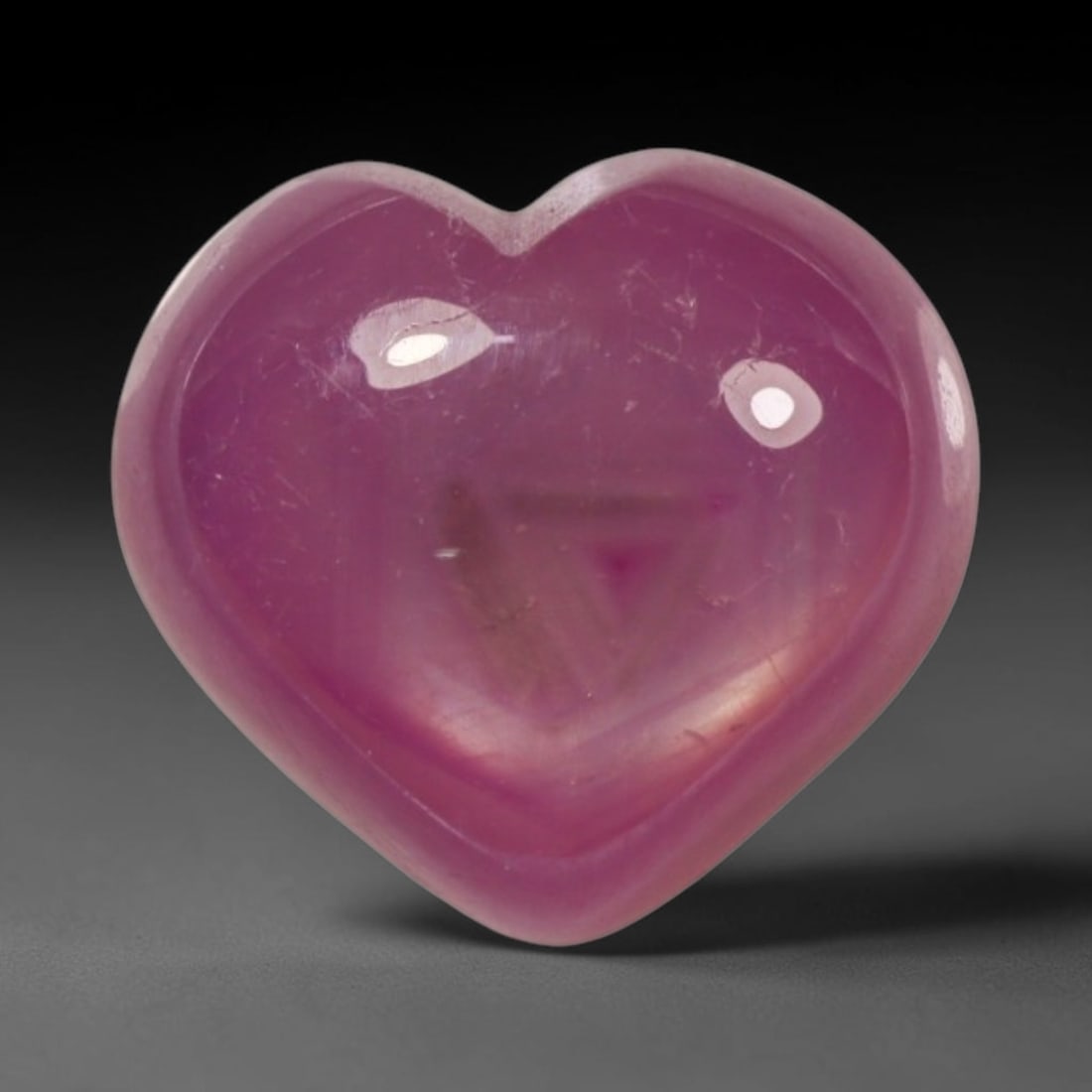 4.85ct Natural Mozambique Hot Pink Ruby Loose Gemstone, 72BP: This heart shaped Mozambique ruby cabochon measures 10.1x9.6x4.7mm, showcasing a vivid saturated hot pink body paired with stunning natural hexagonal crystal growth banding that forms a distinct geome