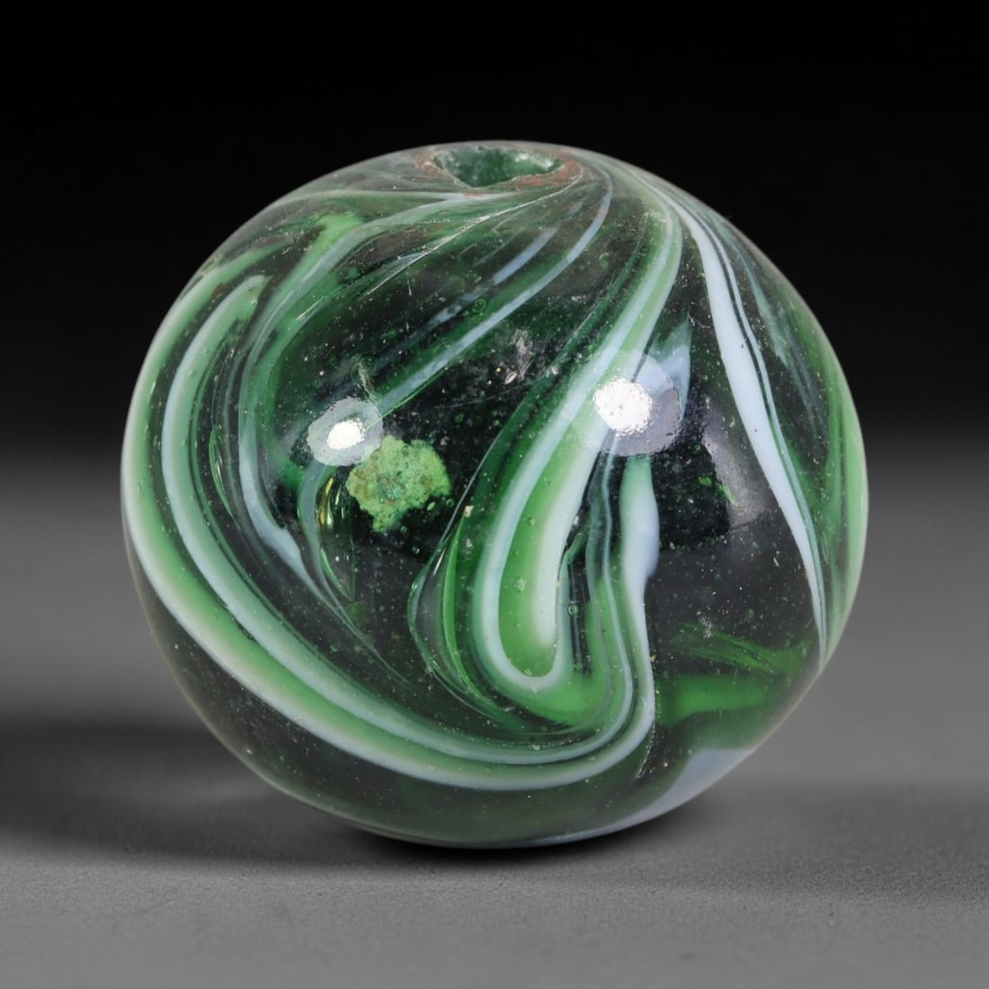Swirled Green Blown Glass Bead - Handmade Vintage Spherical Ornament, 19AE: Hand-blown glass composes this spherical bead, defined by fluid layered swirls of deep emerald green, soft mint green and opaque white glass forming continuous marbled striations across its polished e
