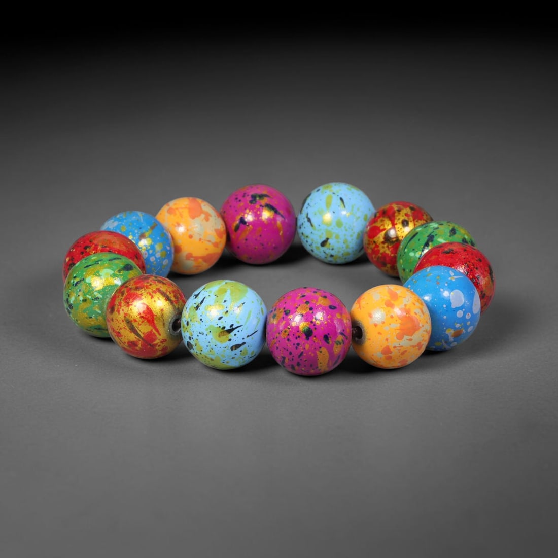 A Chinese Artistic Paint Wood Beaded Bracelet, 15mm Beads, 65BX: Completed bracelet assembled from wooden spherical beads with distinctive artistic paint finish, each bead measuring 15 mm. Vibrant multi-tonal speckled surface detailing is applied across each bead, 