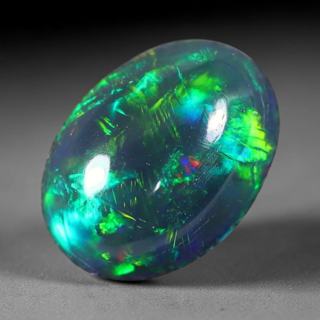 1.85ct Natural Ethiopian Welo Black Smoked Opal Cabochon Loose Gemstone, 40FX: This fully polished Ethiopian Welo opal features a dark smoked base with vivid, sweeping play-of-color shifting across its glossy dome surface, measured at 10x8x5mm. The black smoke treatment deepens 