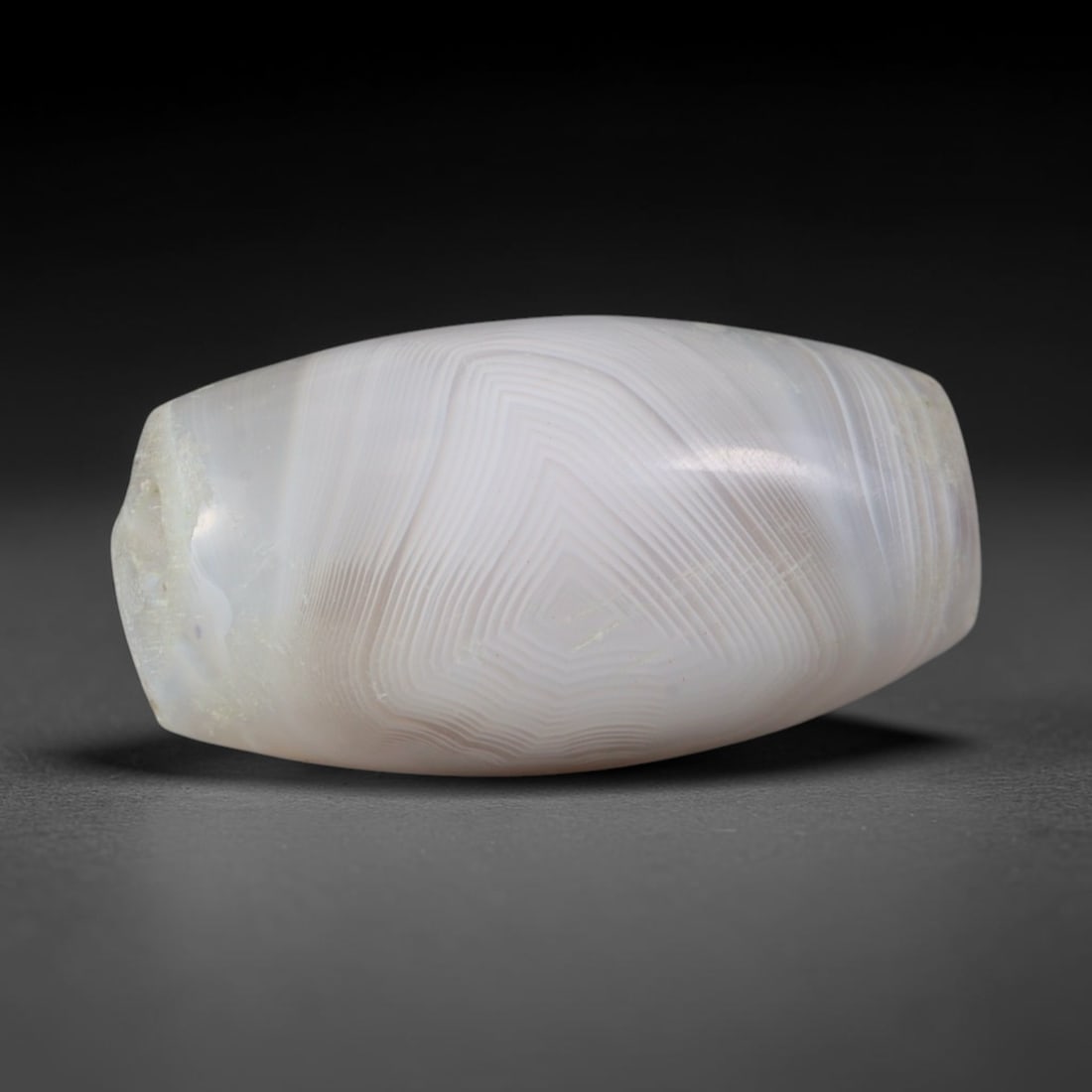 Ancient Seleucid Empire Fine Stepped Geometric Banded Agate Barrel Bead (312-63 BCE), 68AD: This antique finely layered banded agate barrel bead originates from the Seleucid Empire, a Hellenistic Near Eastern civilization that fused Greek and Persian stoneworking traditions to craft talisman