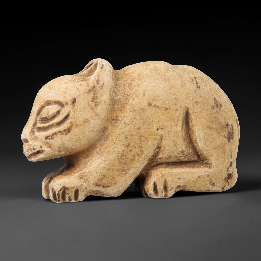 Ancient Stone Rodent Figurine - Near Eastern Animal Amulet, 64BF: Carved from a light tan stone with a naturally aged patina, this figurine depicts a stylized rodent in a crouched, forward-facing posture. The animal's form is rendered with expressive, rounded propor
