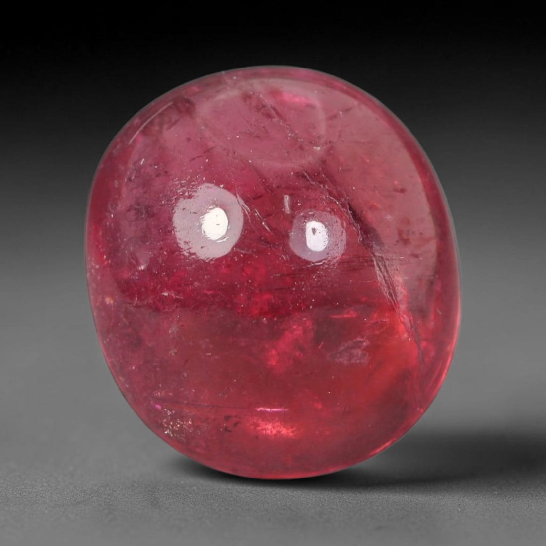 3.46ct Natural Brazilian Rubellite Tourmaline Cabochon Loose Gemstone, 25BC: This smoothly polished cabochon rubellite tourmaline features layered saturated pink-red body saturation with dense natural crystalline mineral flecks and fine internal fracture markings concentrated 