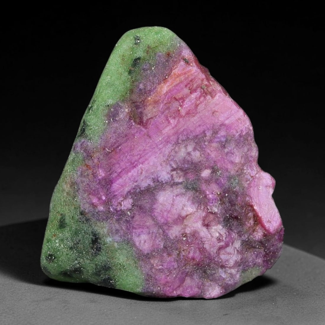 61ct Natural Tanzanian Ruby Zoisite Raw Rough Specimen Mineral Stone, 9FC: This unpolished mineral rough is natural ruby zoisite sourced from Tanzania, exhibiting distinct banded mineral segregation of vibrant green zoisite, magenta ruby crystals, and dark hornblende inclusi