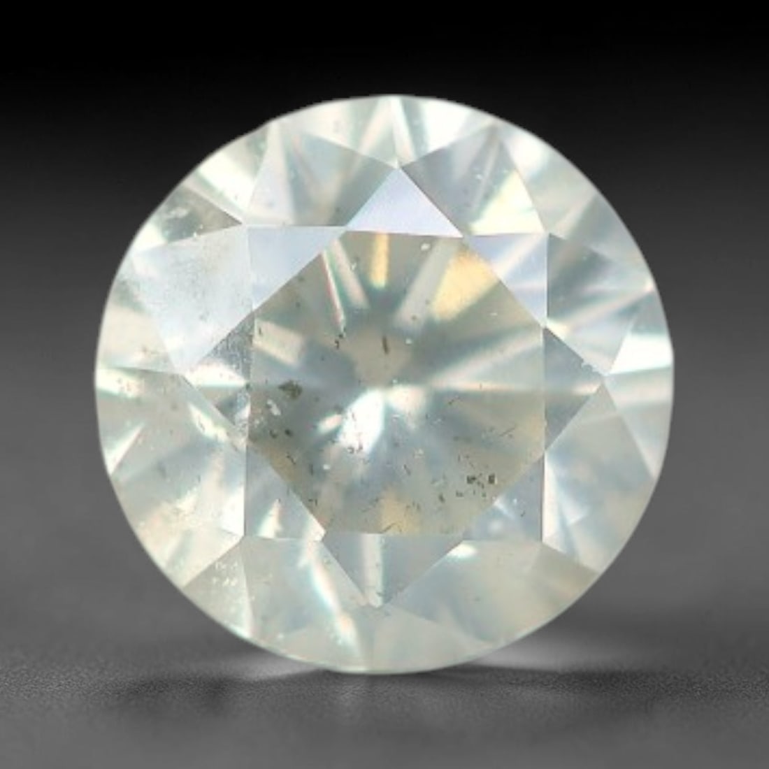 0.16ct Round Natural Fancy Greenish Yellow Diamond Loose Gemstone, 37BH: This polished natural round fancy diamond displays a delicate greenish-yellow base tone, with scattered fine native mineral specks distributed within its crystalline interior, measured at calibrated d