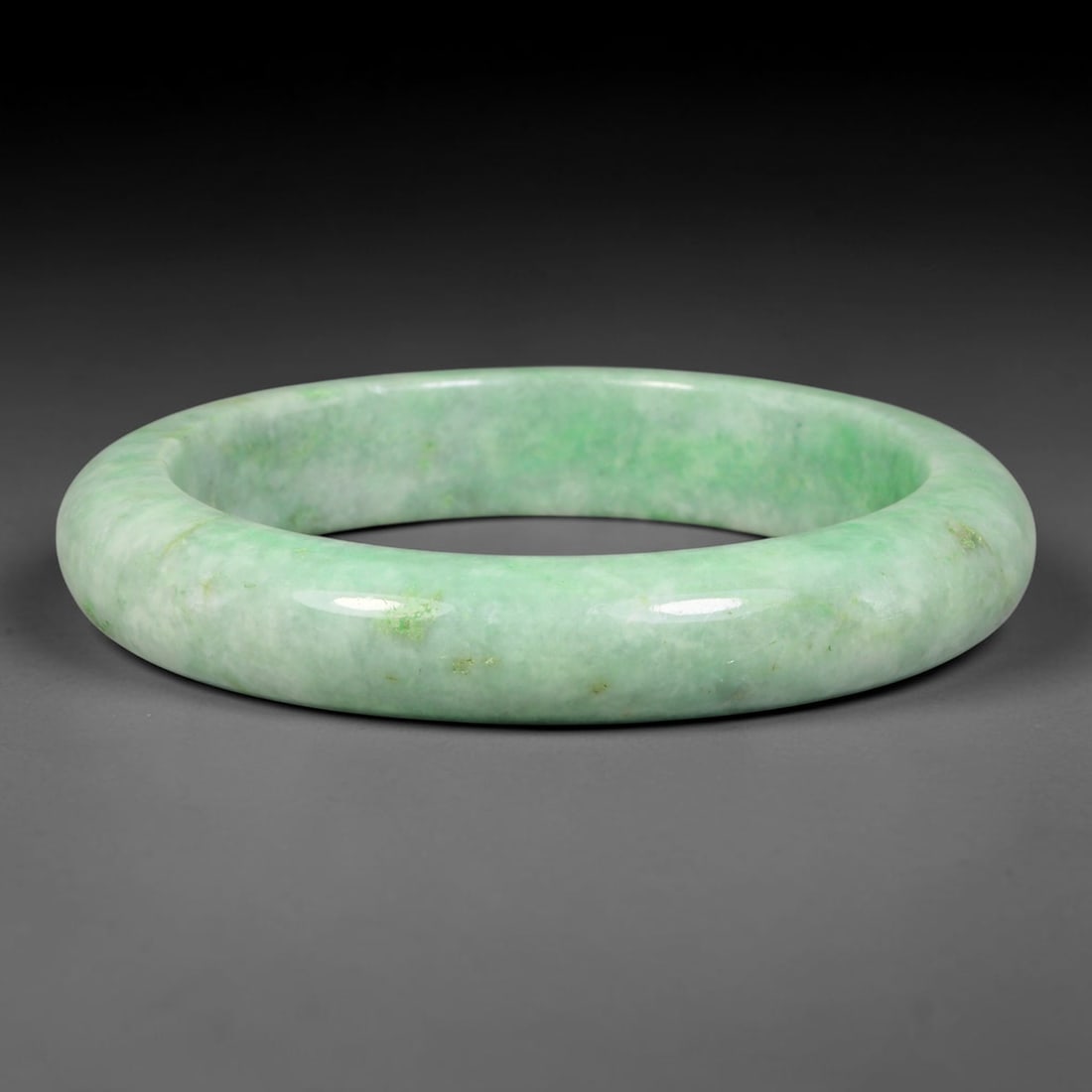 Natural Burmese Type A Light Green Jadeite Jade Bangle Bracelet, 51EC: Crafted from natural Burmese Type A jadeite jade, this large-size bangle carries consistent pale apple green with scattered tiny green flecks across the milky base, forming a subtle Moss in Snow patte