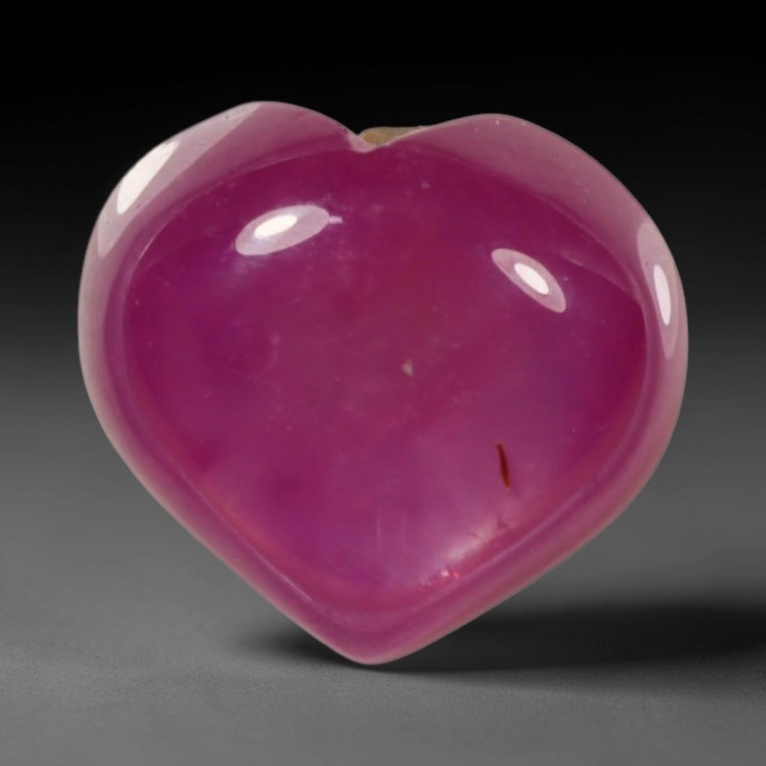 6.15ct Natural Mozambique Hot Pink Ruby Loose Gemstone, 75BP: This heart shaped Mozambique ruby cabochon measures 10.2x9.2x5.7mm, showcasing a vivid saturated hot pink body paired with stunning natural hexagonal crystal growth banding that forms a distinct geome