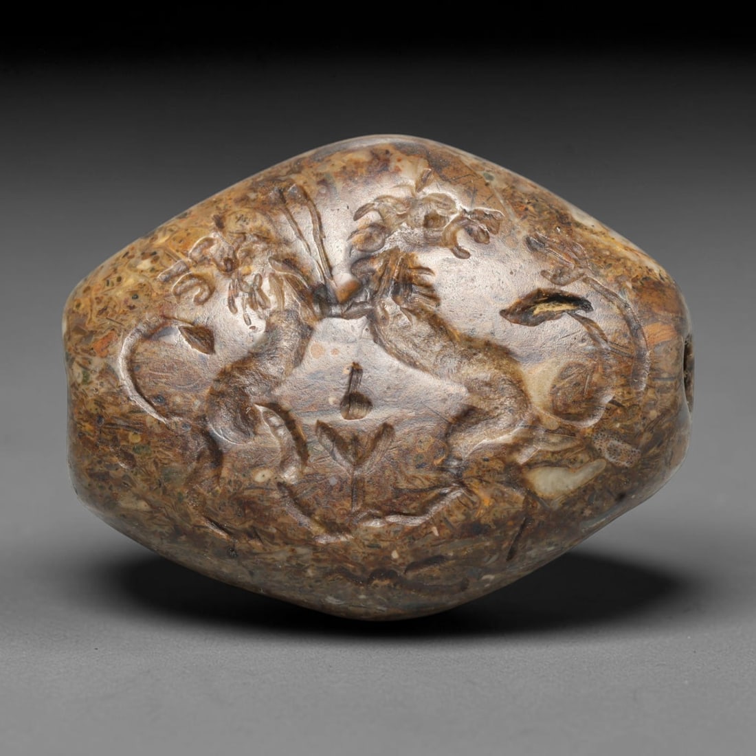Ancient Sasanian Persian Intaglio Bead (224-651 CE), 96EC: This antique intaglio bead originates from the Sasanian Persian Empire, celebrated for carved stone beads crafted as wearable talismans and markers of identity throughout late antiquity. The fossil-be