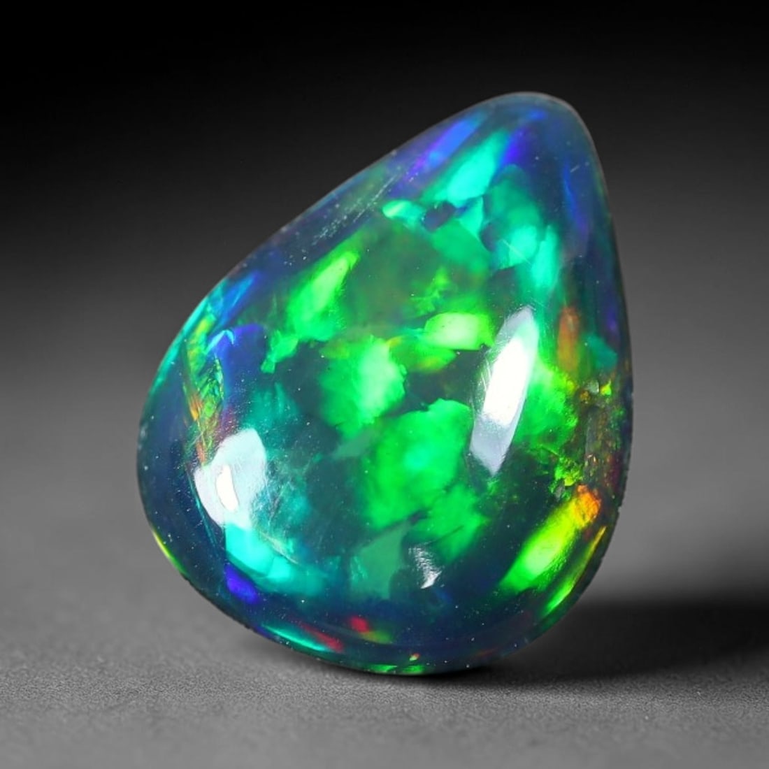1.43ct Natural Ethiopian Welo Black Smoked Opal Cabochon Loose Gemstone, 47FX: This fully polished Ethiopian Welo opal features a dark smoked base with vivid, sweeping play-of-color shifting across its glossy dome surface, measured at 10x8x3mm. The black smoke treatment deepens 