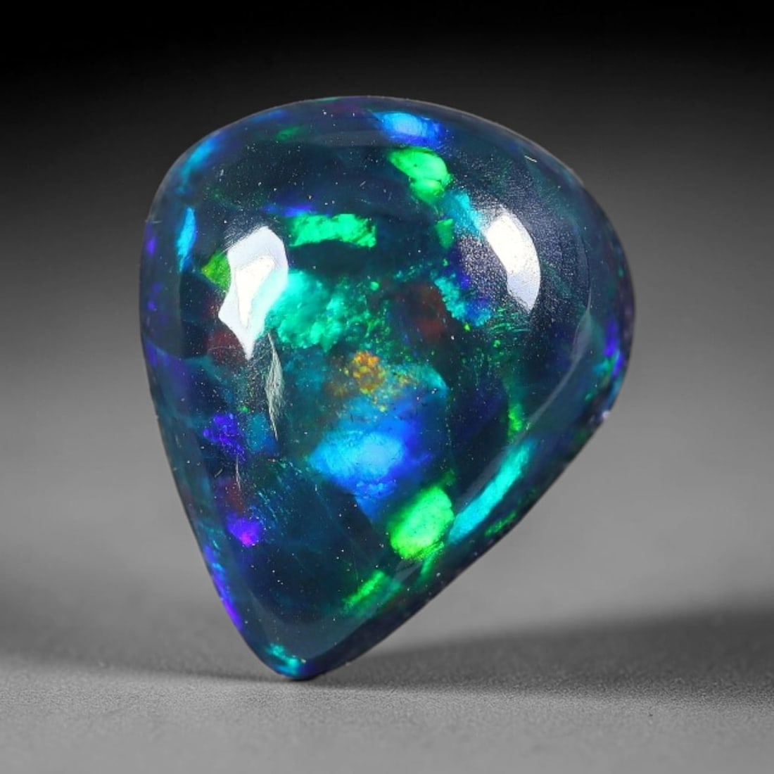 2.14ct Natural Ethiopian Welo Black Smoked Opal Cabochon Loose Gemstone, 31FX: This fully polished Ethiopian Welo opal features a dark smoked base with vivid, sweeping play-of-color shifting across its glossy dome surface, measured at 10x8x5mm. The black smoke treatment deepens 