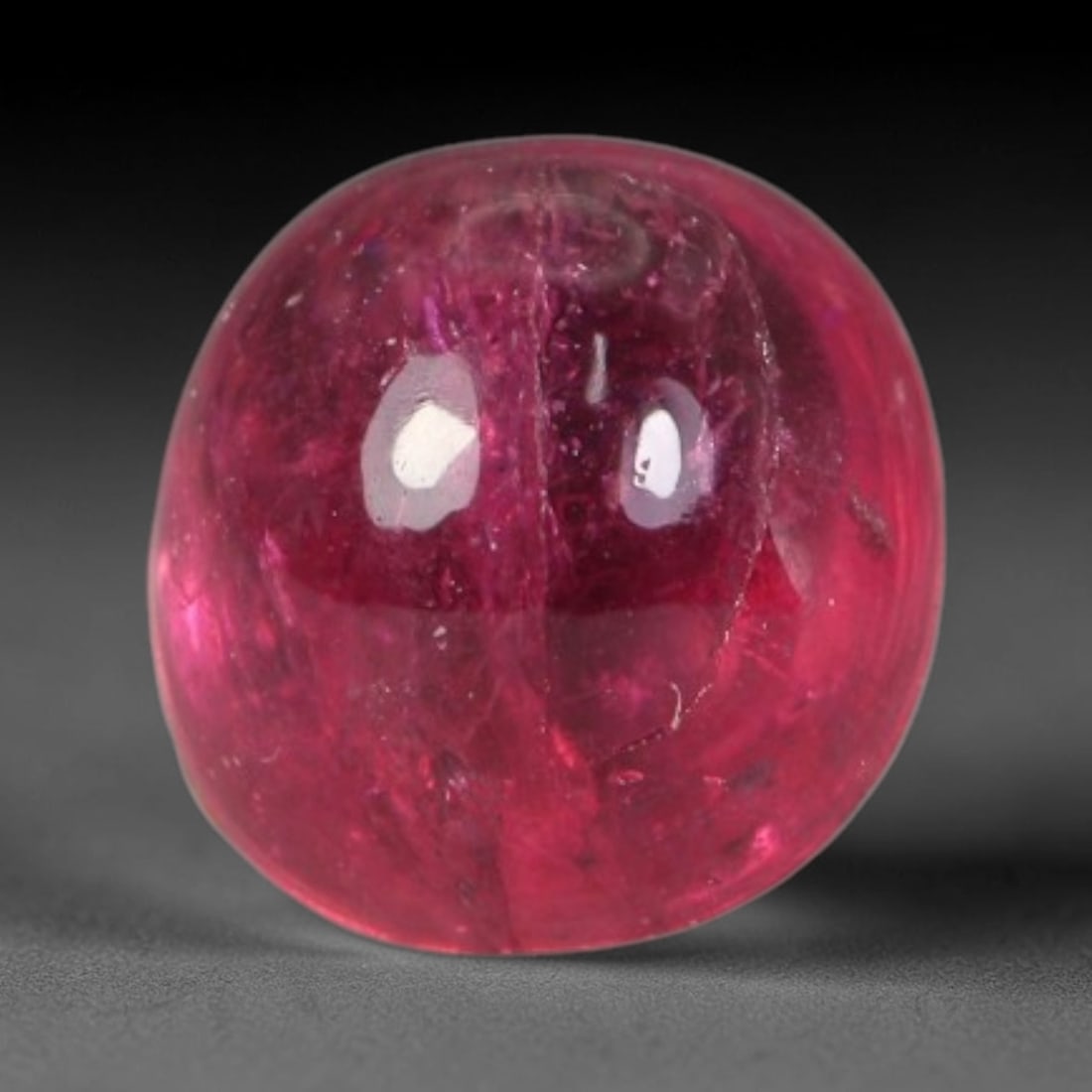 1.05ct Natural Brazilian Rubellite Tourmaline Cabochon Loose Gemstone, 50BC: This smoothly polished cabochon rubellite tourmaline features layered saturated pink-red body saturation with dense natural crystalline mineral flecks and fine internal fracture markings concentrated 