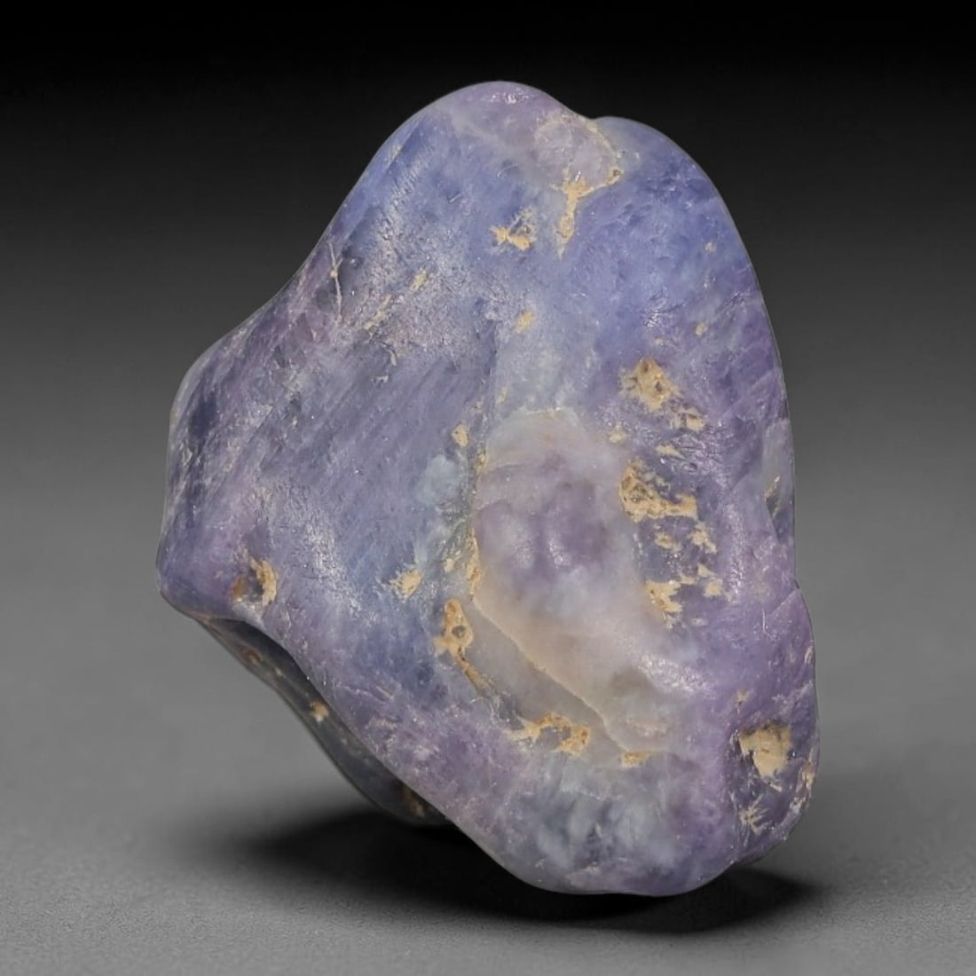 28.40ct Natural Unheated Sri Lankan Purplish Blue Sapphire Rough, 89FC: This natural corundum rough is an unheated purplish blue sapphire sourced from Sri Lankan alluvial gem deposits, featuring an irregular natural native form with residual pale yellow-brown mineral matr