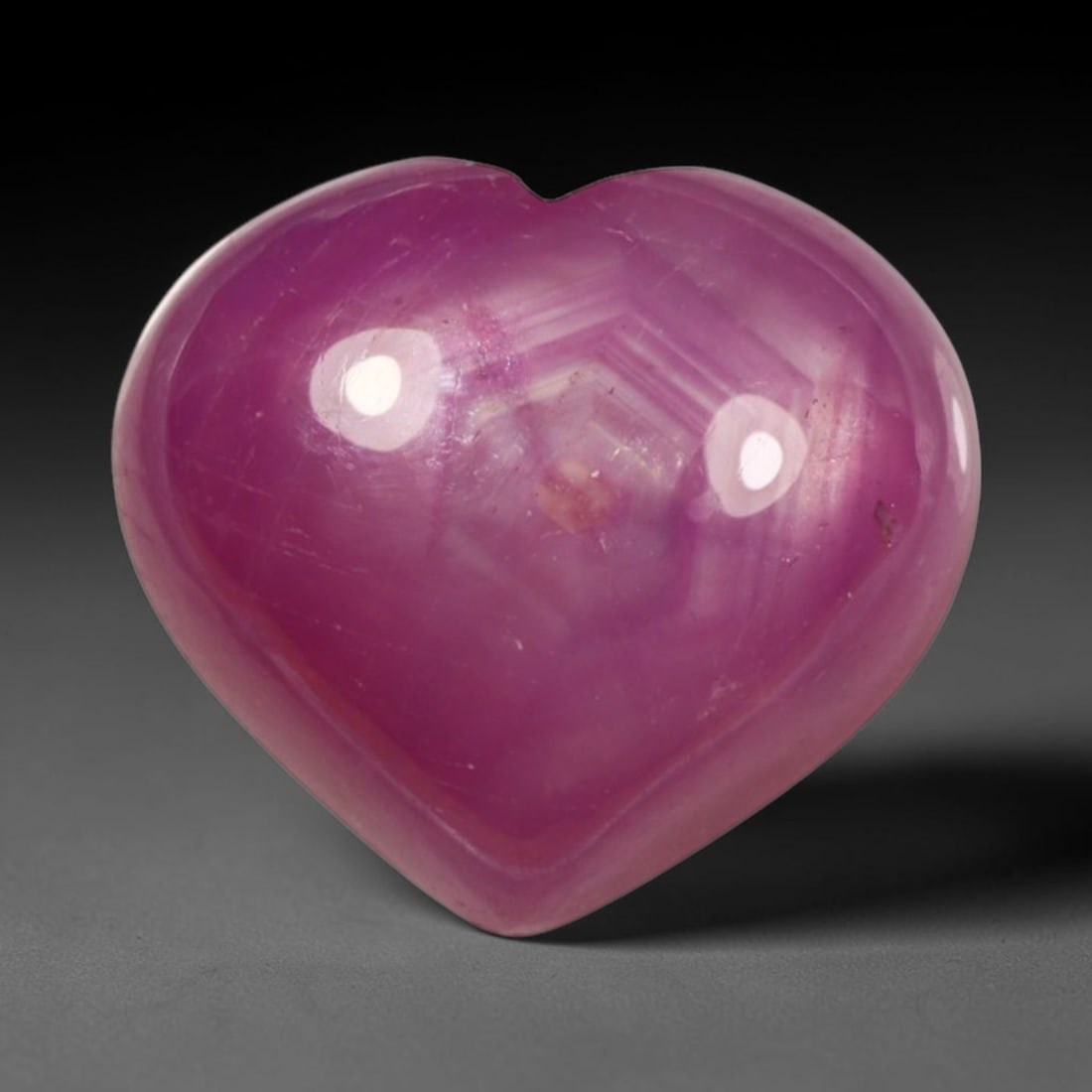 6.49ct Natural Mozambique Hot Pink Ruby Loose Gemstone, 71BP: This heart shaped Mozambique ruby cabochon measures 11.3x10x5.2mm, showcasing a vivid saturated hot pink body paired with stunning natural hexagonal crystal growth banding that forms a distinct geomet